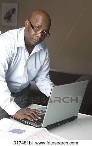 portrait of black businessman working with laptop at home View Large Photo Image Stock Image - portrait of black businessman working with laptop at home. Fotosearch