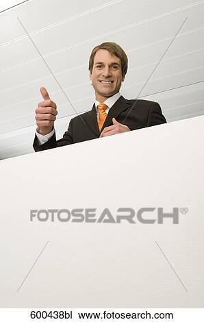 Stock Image - portrait of businessman doing the tumbs up sign. Fotosearch