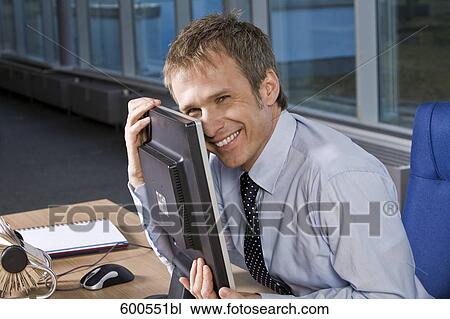 Stock Image - portrait of businessman embracing his computer monitor. Fotosearch