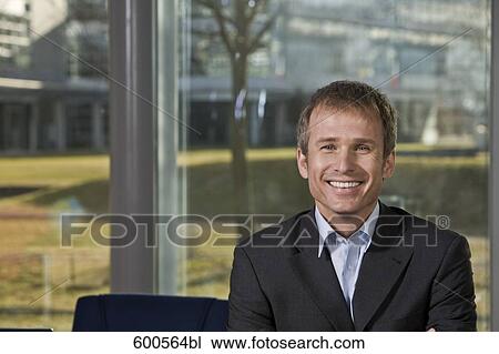 Stock Image - portrait of businessman in front of window. Fotosearch
