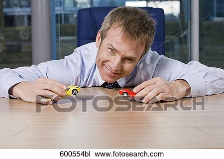 portrait of businessman playing with toy cars View Large Photo Image Stock Image - portrait of businessman playing with toy cars. Fotosearch