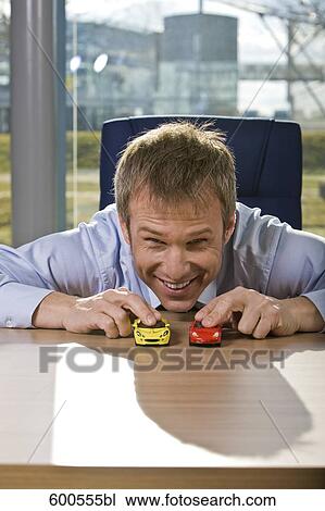 portrait of businessman playing with toy cars View Large Photo Image Stock Image - portrait of businessman playing with toy cars. Fotosearch