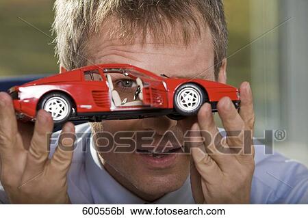 portrait of businessman playing with toy car View Large Photo Image Stock Image - portrait of businessman playing with toy car. Fotosearch
