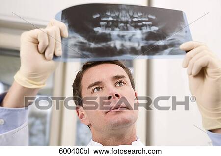 portrait of dentist looking at x-ray of patient View Large Photo Image Stock Image - portrait of dentist looking at x-ray of patient. Fotosearch