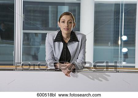portrait of female executive leaning against railing in office building View Large Photo Image Stock Image - portrait of female executive leaning against railing in office building. Fotosearch