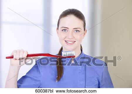 portrait of medical assistant holding large toothbrush View Large Photo Image Stock Image - portrait of medical assistant holding large toothbrush. Fotosearch