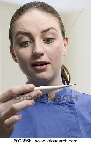 Stock Image - portrait of nurse holding thermometer. Fotosearch