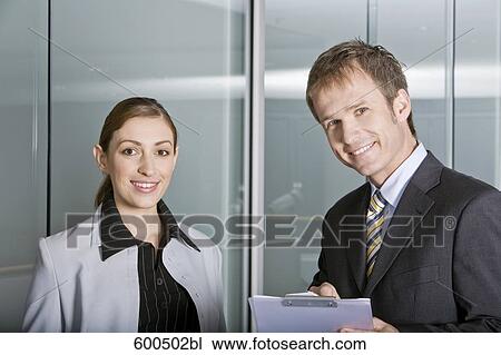 Stock Image - portrait of two executives having conversation in corridor of office building. Fotosearch