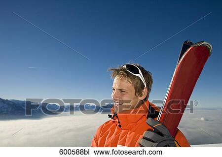 portrait of young in the mountains holding skis View Large Photo Image Stock Image - portrait of young in the mountains holding skis. Fotosearch