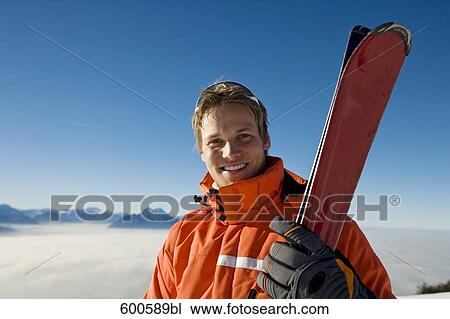 portrait of young in the mountains holding skis View Large Photo Image Stock Image - portrait of young in the mountains holding skis. Fotosearch