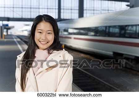 Stock Image - portrait of young japanese woman at train station. Fotosearch