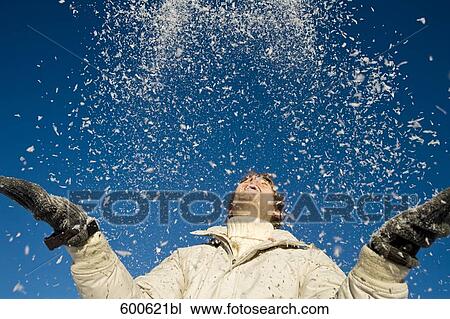 Stock Image - portrait of young man playing with snow. Fotosearch