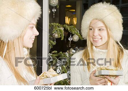 portrait of young with christmas present looking at herself in the mirror View Large Photo Image Stock Image - portrait of young with christmas present looking at herself in the mirror. Fotosearch