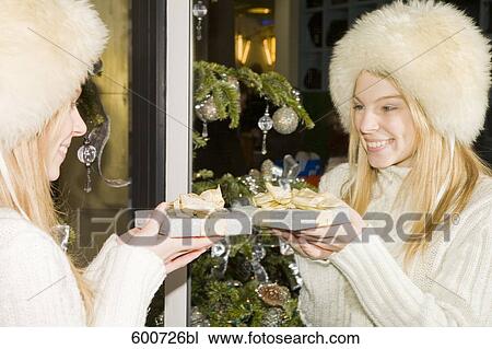 portrait of young with christmas present looking at herself in the mirror View Large Photo Image Stock Image - portrait of young with christmas present looking at herself in the mirror. Fotosearch