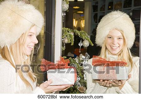 portrait of young with christmas present looking at herself in the mirror View Large Photo Image Stock Image - portrait of young with christmas present looking at herself in the mirror. Fotosearch