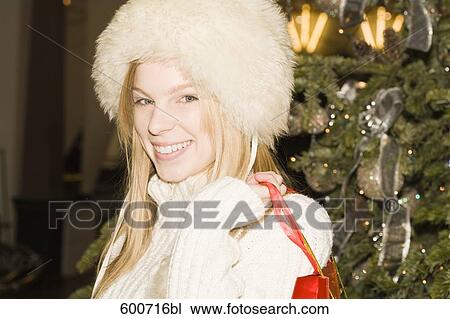 portrait of young woman carrying bags with christmas shoppings View Large Photo Image Stock Image - portrait of young woman carrying bags with christmas shoppings. Fotosearch