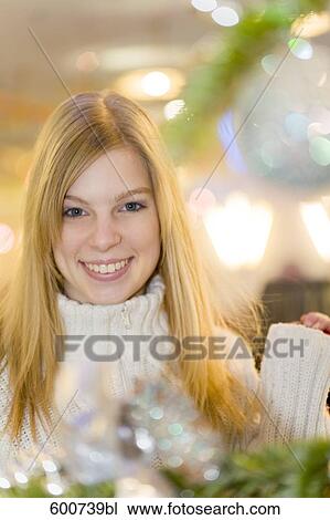 portrait of young woman in front of christmas decoration View Large Photo Image Stock Image - portrait of young woman in front of christmas decoration. Fotosearch