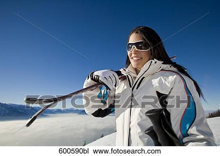 portrait of young woman in the mountains carrying skis View Large Photo Image Stock Image - portrait of young woman in the mountains carrying skis. Fotosearch