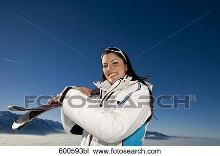 portrait of young woman in the mountains carrying skis View Large Photo Image Stock Image - portrait of young woman in the mountains carrying skis. Fotosearch