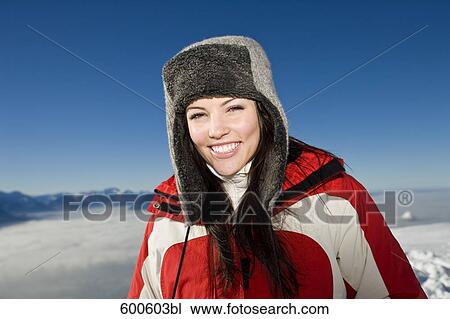 Stock Image - portrait of young woman in the mountains wearing hat. Fotosearch
