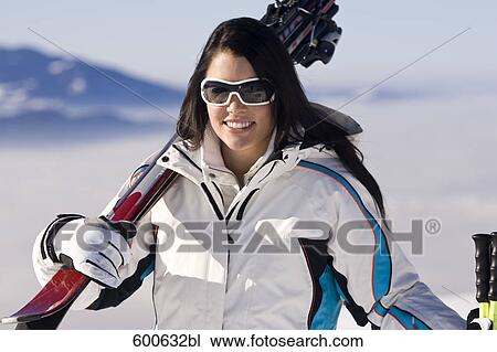 portrait of young woman in the mountains carrying skis View Large Photo Image Stock Image - portrait of young woman in the mountains carrying skis. Fotosearch