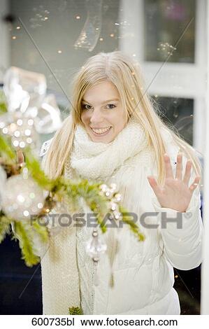 portrait of young woman looking through shop window with christmas decoration View Large Photo Image Stock Image - portrait of young woman looking through shop window with christmas decoration. Fotosearch