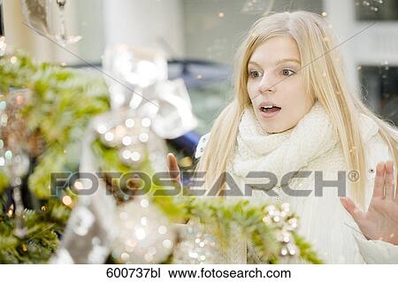 portrait of young woman looking through shop window with christmas decoration View Large Photo Image Stock Image - portrait of young woman looking through shop window with christmas decoration. Fotosearch