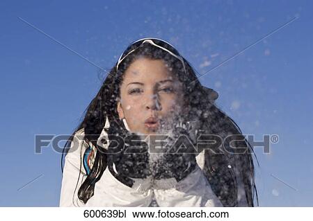 Stock Image - portrait of young woman playing with snow. Fotosearch