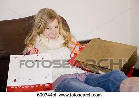 portrait of young woman sitting at home with shopping bags View Large Photo Image Stock Image - portrait of young woman sitting at home with shopping bags. Fotosearch