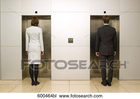 rear view of businesswoman and male colleague standing in front of elevator View Large Photo Image Stock Image - rear view of businesswoman and male colleague standing in front of elevator. Fotosearch