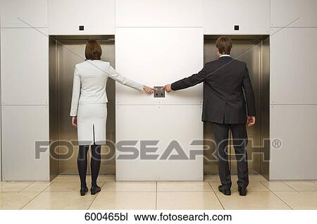 rear view of businesswoman and male colleague standing in front of elevator View Large Photo Image Stock Image - rear view of businesswoman and male colleague standing in front of elevator. Fotosearch