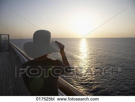 rear view of woman on cruise ship looking at horizon sun is setting View Large Photo Image Stock Image - rear view of woman on cruise ship looking at horizon sun is setting. Fotosearch
