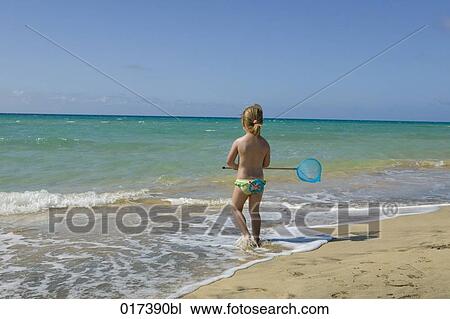 rear view of young girl on beach walking into water with spoon net View Large Photo Image Stock Image - rear view of young girl on beach walking into water with spoon net. Fotosearch