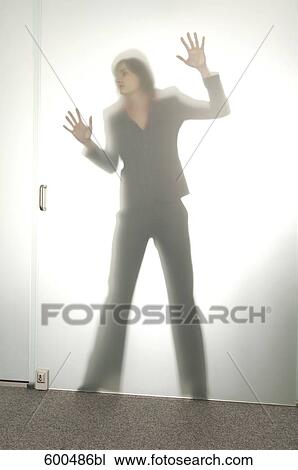 Stock Image - shape of businesswoman behind glass door. Fotosearch