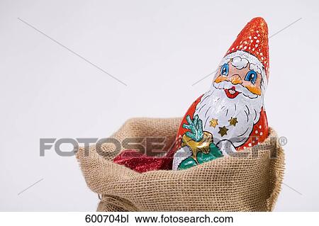 Stock Image - still life of chocolate santa claus in sack. Fotosearch