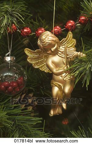 Stock Image - still life of golden angel hanging on christmas tree. Fotosearch