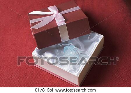 still life of open gift box containing pacifier View Large Photo Image Stock Image - still life of open gift box containing pacifier. Fotosearch
