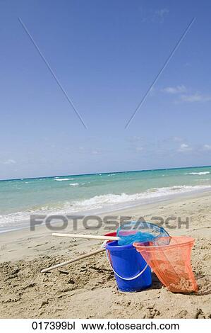 Stock Image - still life of plastic buckets and spoon nets on beach. Fotosearch