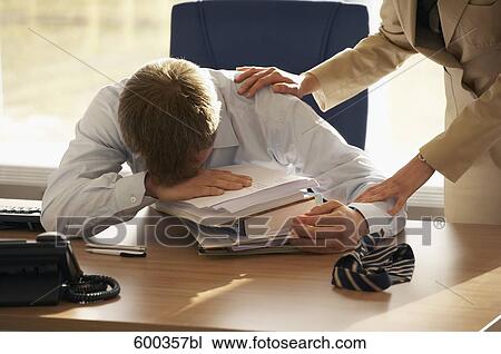 stressed businessman at his desk being helped by female colleague View Large Photo Image Stock Image - stressed businessman at his desk being helped by female colleague. Fotosearch