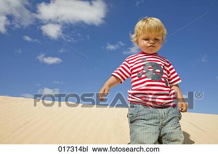 sulking boy standing on sand dune View Large Photo Image Stock Image - sulking boy standing on sand dune. Fotosearch