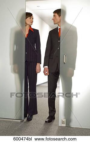 two business people standing side by side behind half open glass door View Large Photo Image Stock Image - two business people standing side by side behind half open glass door. Fotosearch