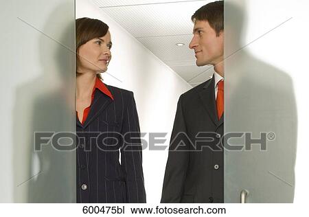 two business people standing side by side behind half open glass door View Large Photo Image Stock Image - two business people standing side by side behind half open glass door. Fotosearch