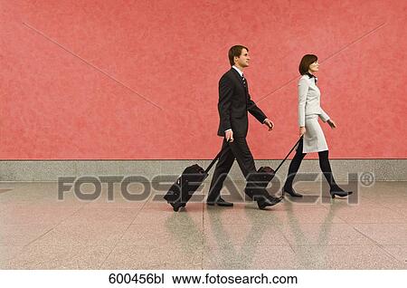 two business travellers in corridor pulling carry-on suitcases View Large Photo Image Stock Image - two business travellers in corridor pulling carry-on suitcases. Fotosearch