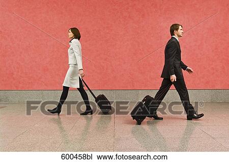 two business travellers in corridor pulling carry-on suitcases View Large Photo Image Stock Image - two business travellers in corridor pulling carry-on suitcases. Fotosearch