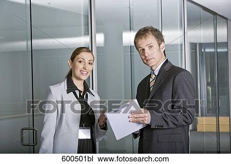 Stock Image - two executives having conversation in corridor of office building. Fotosearch