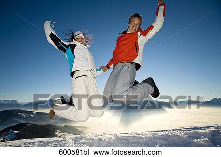 Stock Image - young couple doing jump of joy in the mountains. Fotosearch