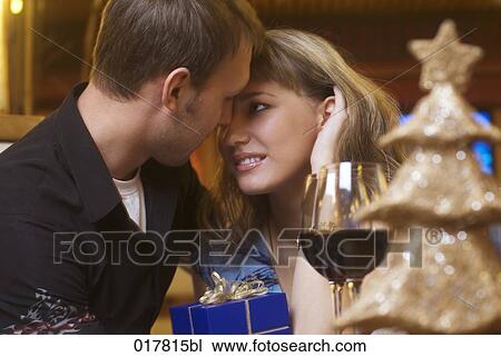 young couple exchanging gifts tenderly looking at each other View Large Photo Image Stock Image - young couple exchanging gifts tenderly looking at each other. Fotosearch