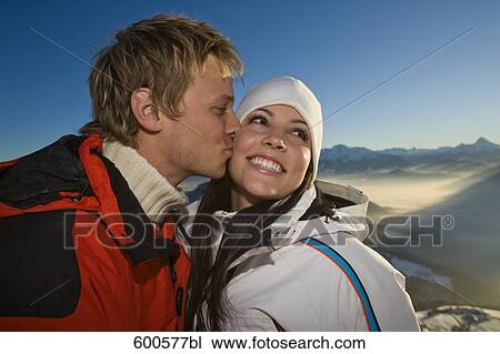young couple in the mountains man kissing woman on cheek View Large Photo Image Stock Image - young couple in the mountains man kissing woman on cheek. Fotosearch