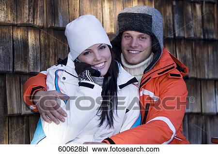 young couple in winter clothes embracing woman talking on mobile phone View Large Photo Image Stock Image - young couple in winter clothes embracing woman talking on mobile phone. Fotosearch