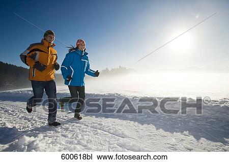 young couple jogging through winter landscape View Large Photo Image Stock Image - young couple jogging through winter landscape. Fotosearch